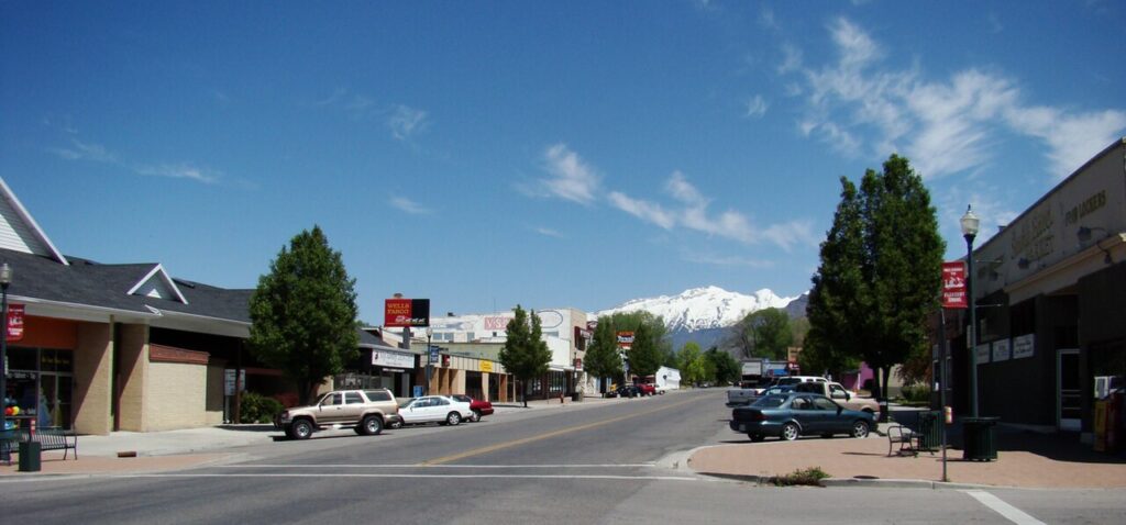 Sunny historic Main Street in Pleasant Grove, Utah with the mountains behind