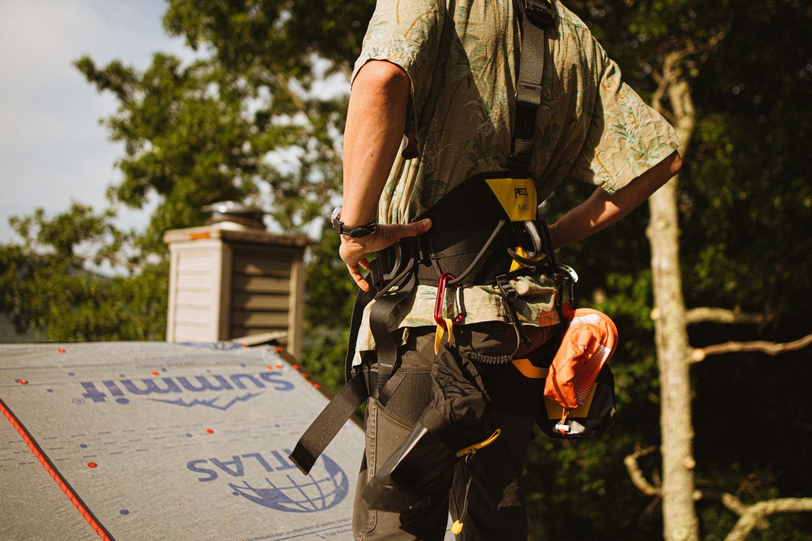 Roofer wearing a safety harness during a roof tune-up inspection