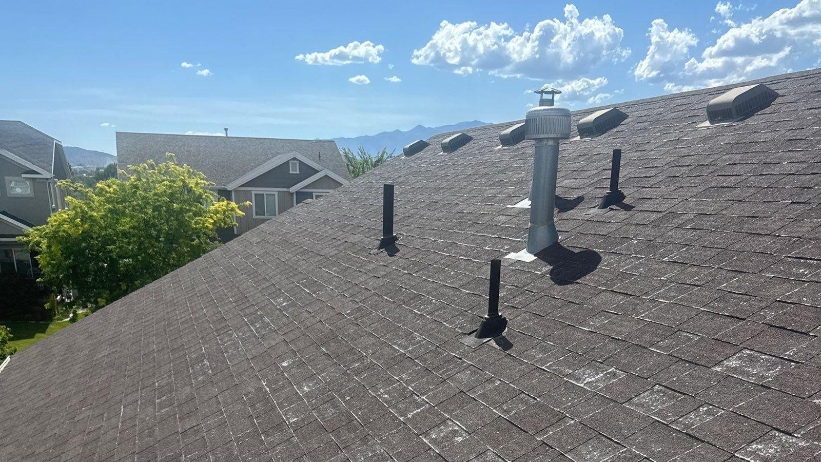 A real Rooval Roofing job in Lehi, Utah: a box vent, plumbing vent boots and a static roof vent sharing one slope.