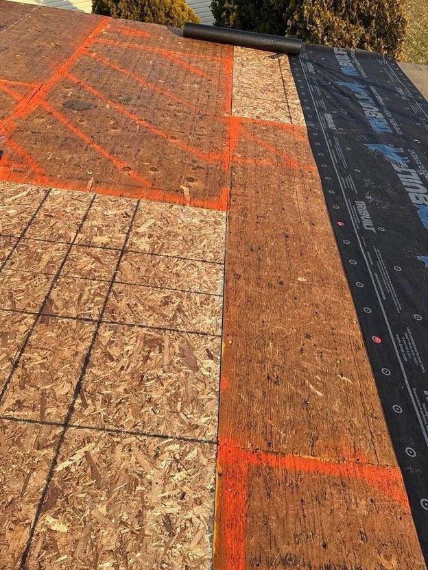 New 7/16-inch OSB infill panel fitted flush into existing plywood roof deck with synthetic underlayment rolled out in Salt Lake County, Utah