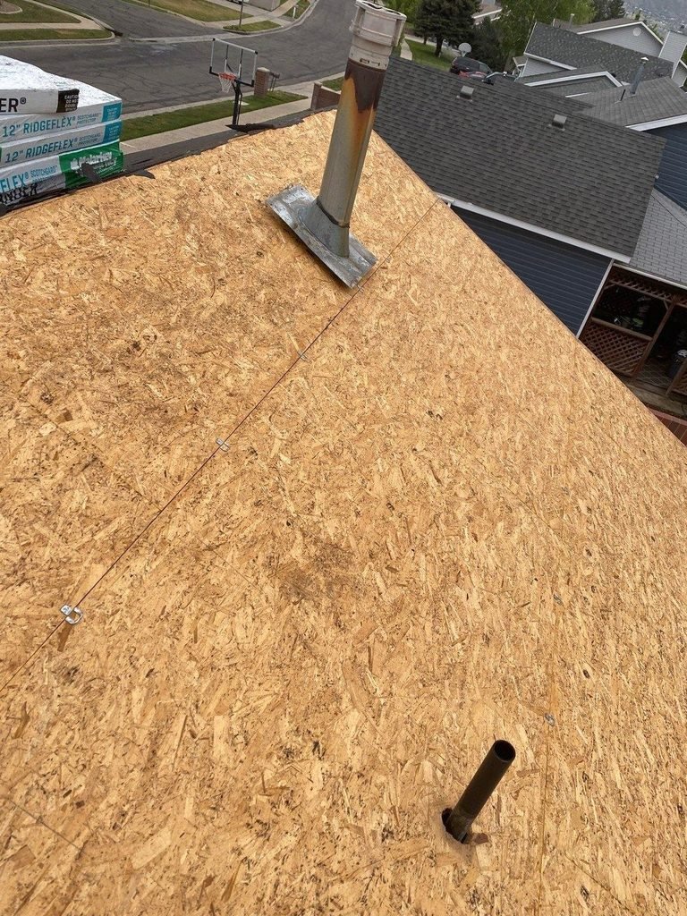 Roof tear-off with new OSB decking installed around a vent pipe before the underlayment goes down