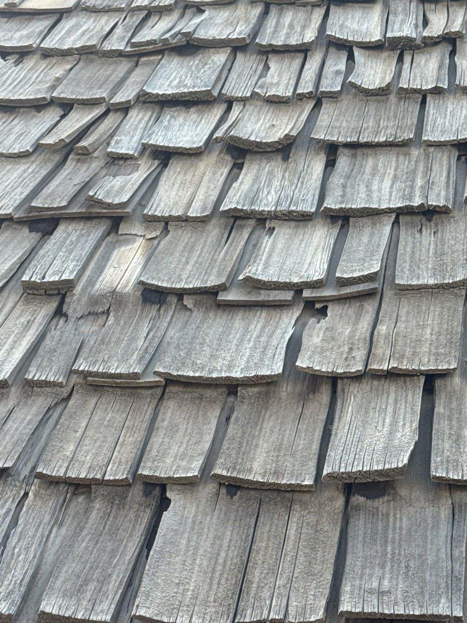 Close-up of split and curling cedar shakes on a roof in Eureka, Utah.