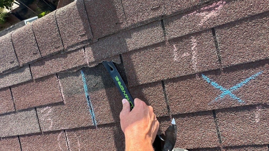 Worn 3-tab asphalt shingle roof marked in chalk during an inspection before replacement